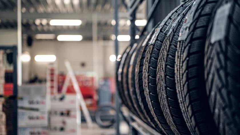 Close-up view of new car tires stacked on display inside an auto repair and tire shop.